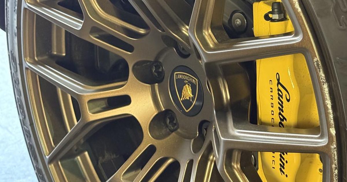 Close-up of a bronze Lamborghini wheel finished at Monaco Wheels, yellow caliper behind the spokes
