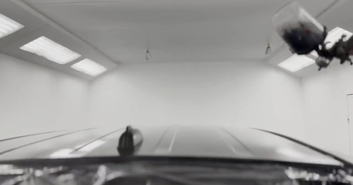 The Monaco Wheels paint booth with a spray gun and a masked vehicle
