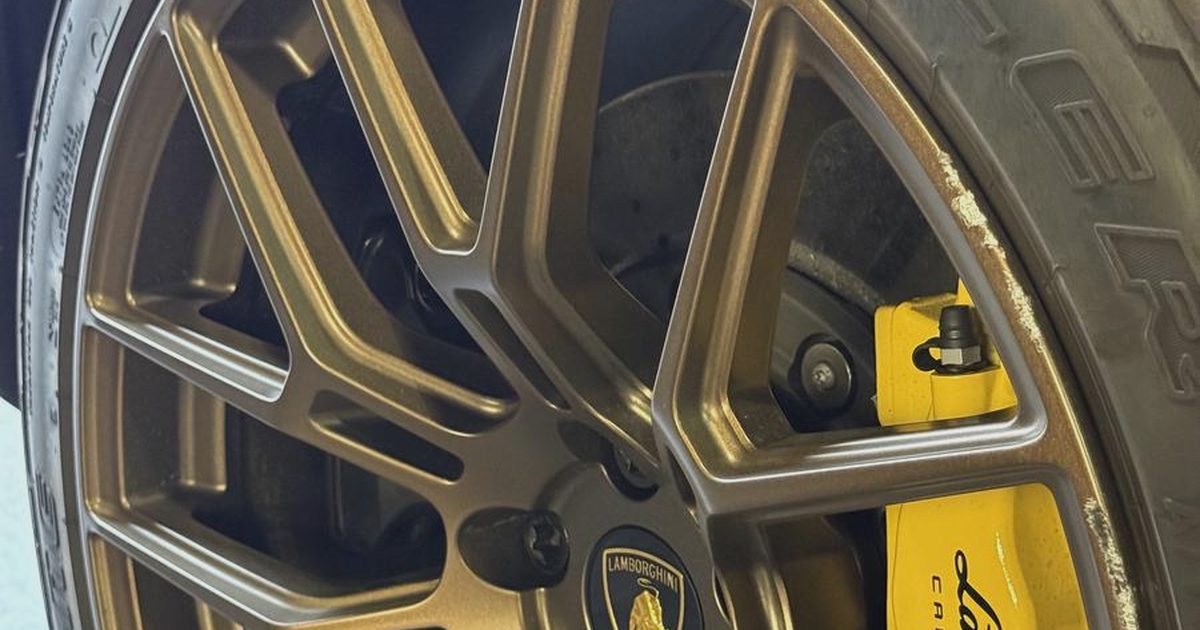 A Lamborghini alloy wheel showing cosmetic kerb damage before repair